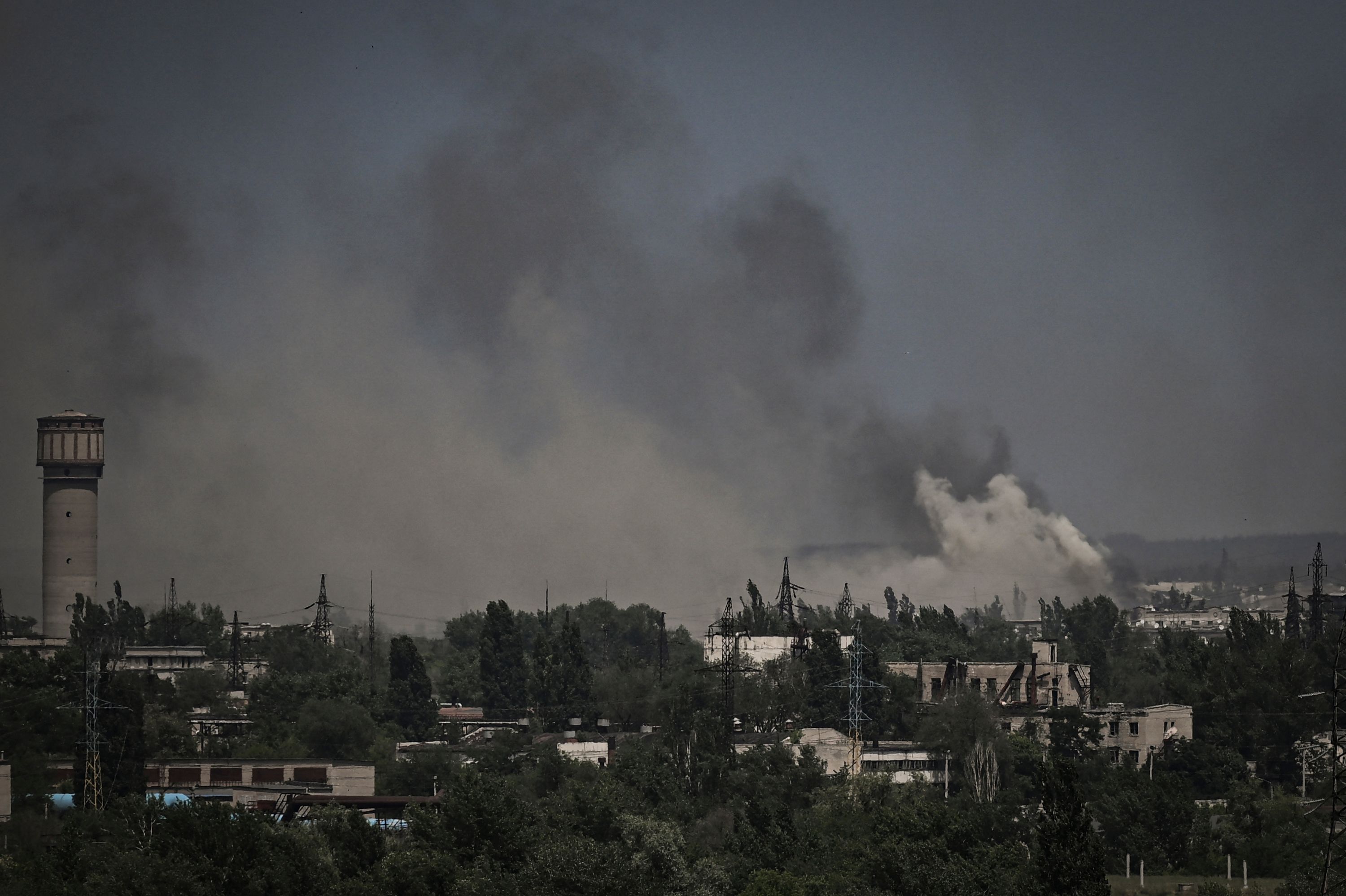 Smoke seen rising above rooftops.