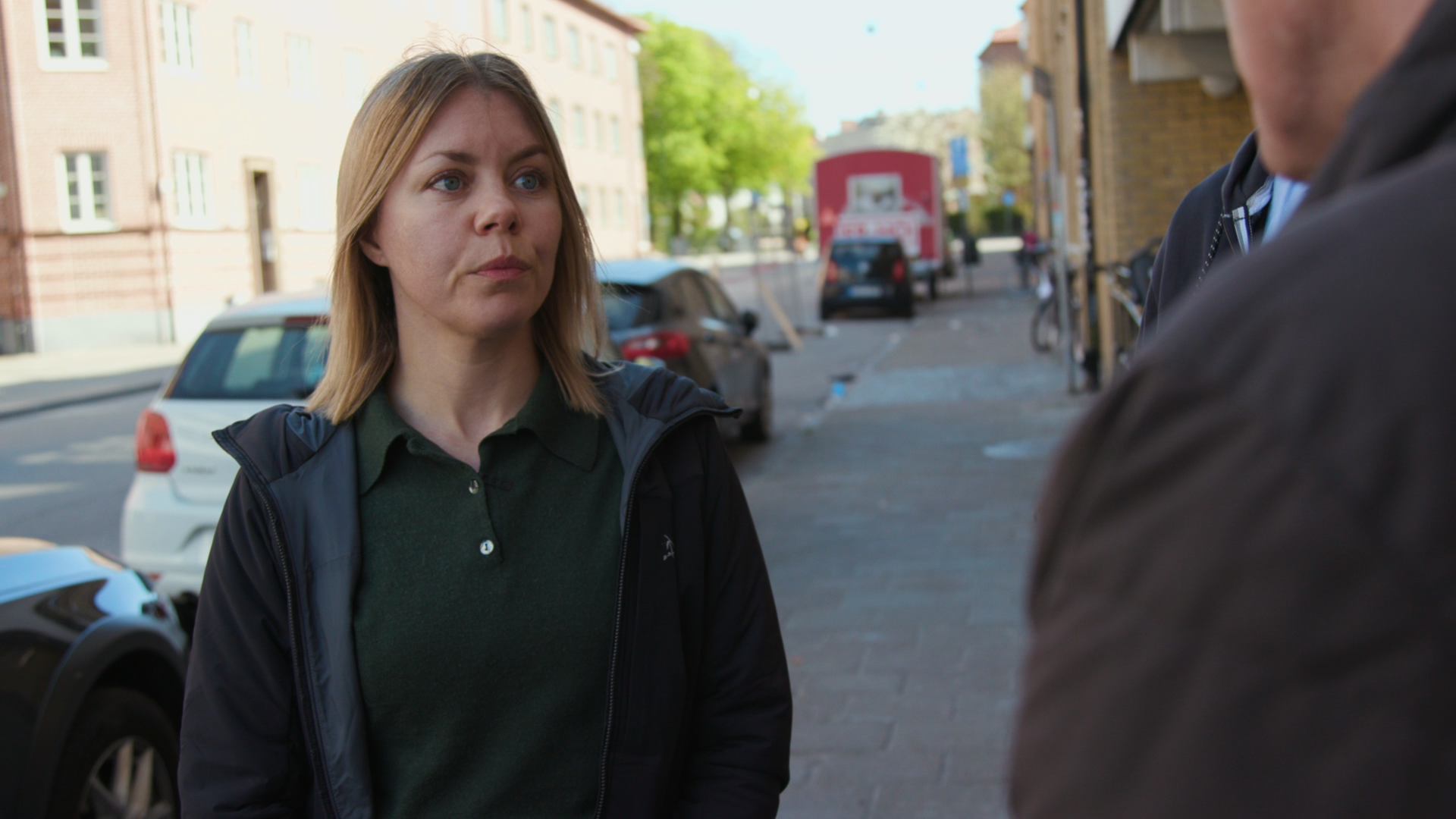 A woman with blonde hair and a green shirt.