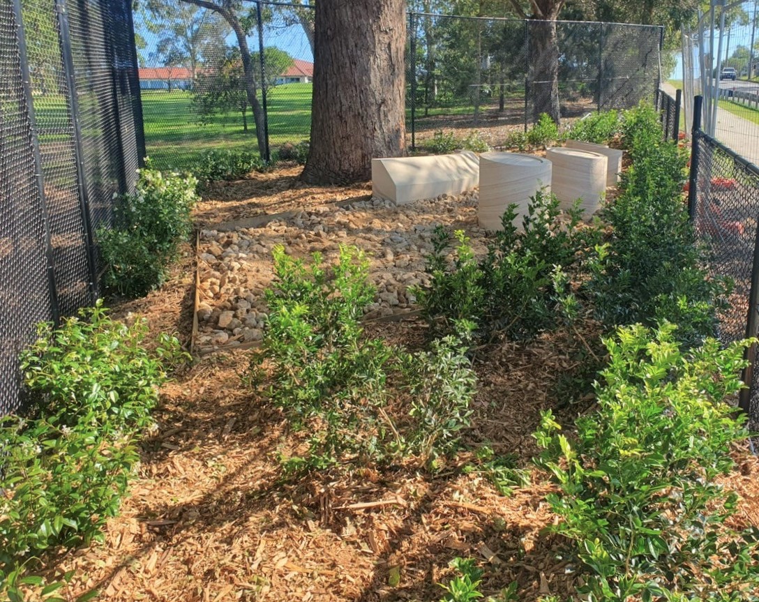 The Oatlands crash site with trees and engraved sandstone memorials.
