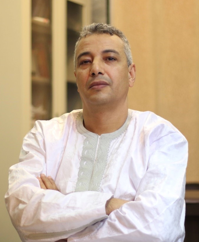 A man in a white shirt with arms crossed