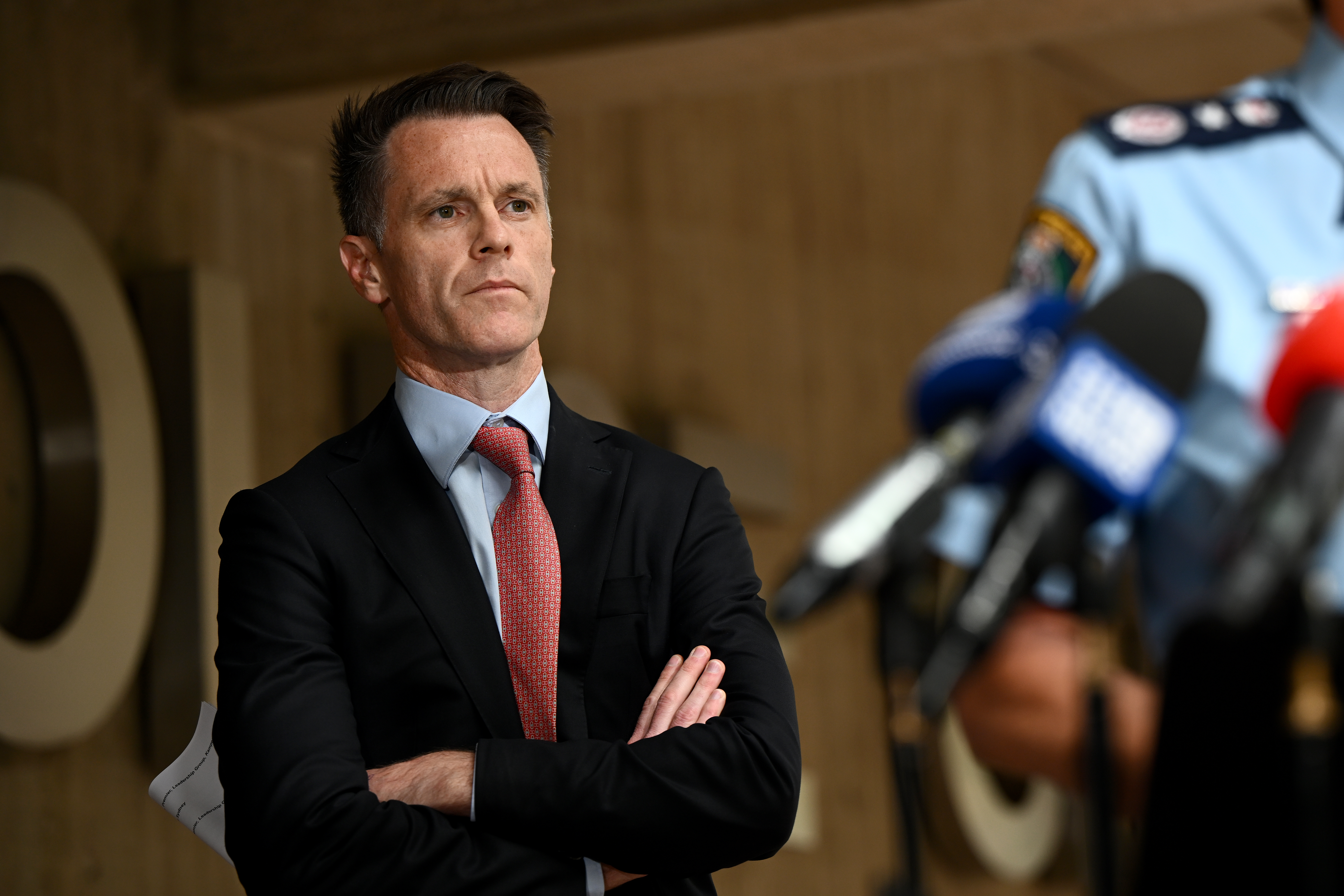 A man in a suit standing with his arms crossed