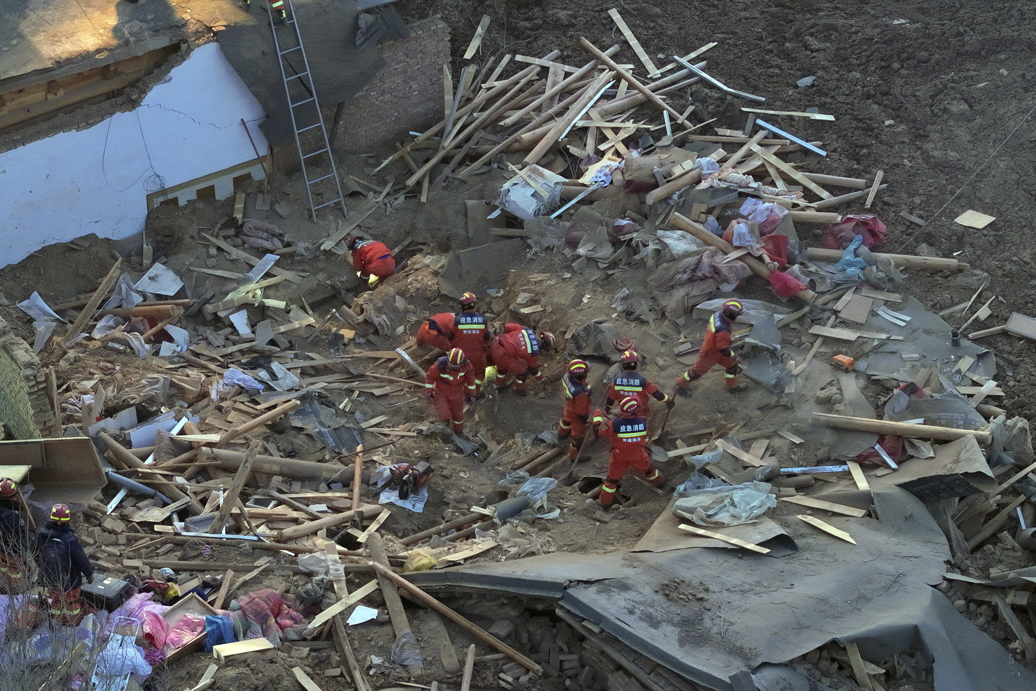 An aerial view of rescue workers working among debris.