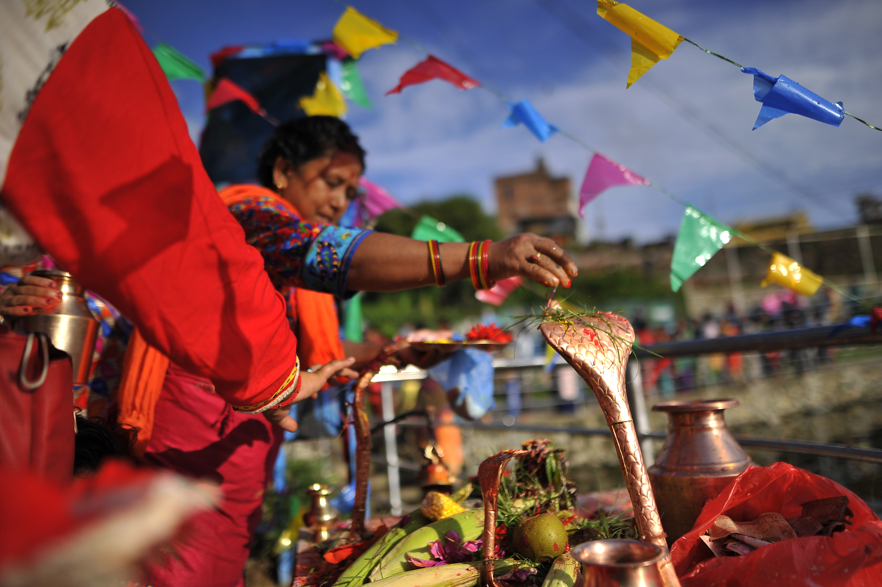 Devotees offering ritual prayer during Nag Panchami at Taudaha Lake in Kirtipur, Kathmandu, Nepal.
