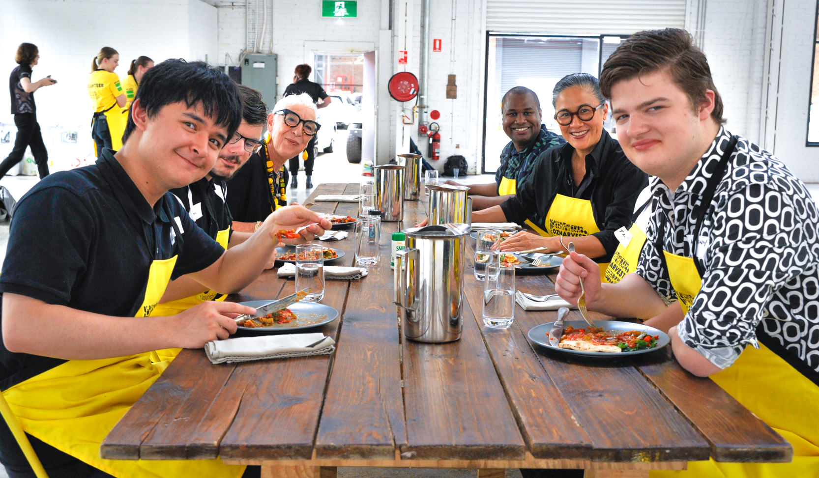 OzHarvest CEO Ronni Kahn (left far back) with chef Kylie Kwong (right) and NEST participants from non-profit group Ability Options.