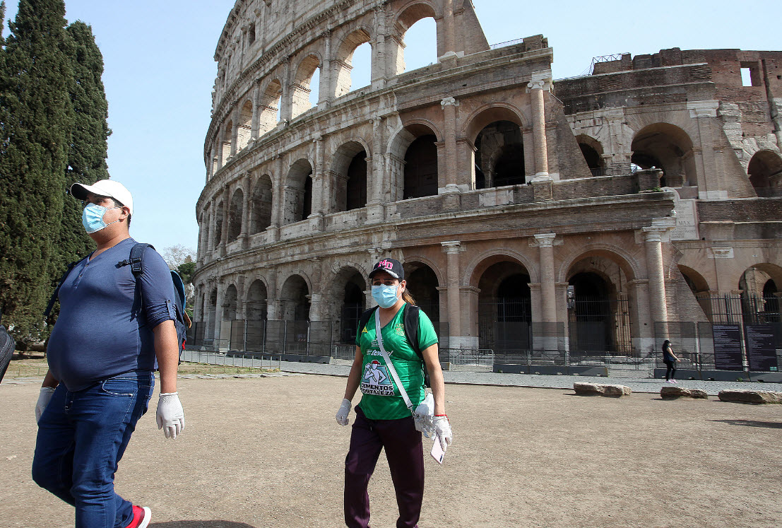 People wearing face masks outside the Colosseum in Rome.