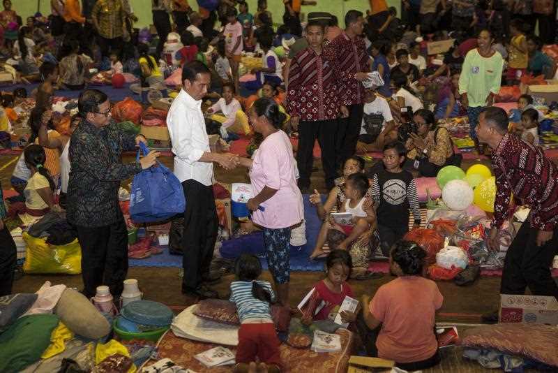 The Indonesian Palace shows Indonesia's President Joko Widodo (white) visits Indonesian displaced people at a shelter in Karangasem on the island of Bali on September 26, 2017.