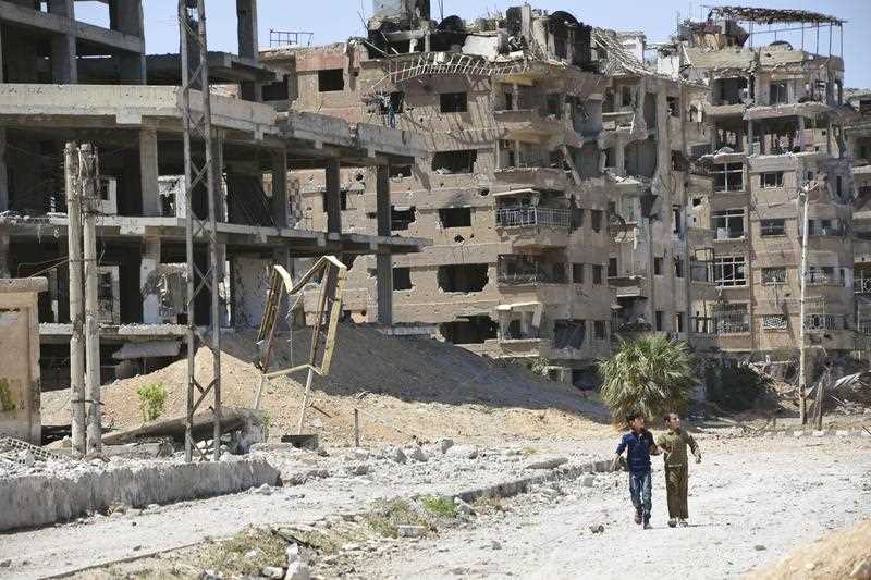 Children walk in a devastated area of Douma in Eastern Ghouta, Syria, on April 16, 2018, where chemical weapons were suspected to have been used against citizens.