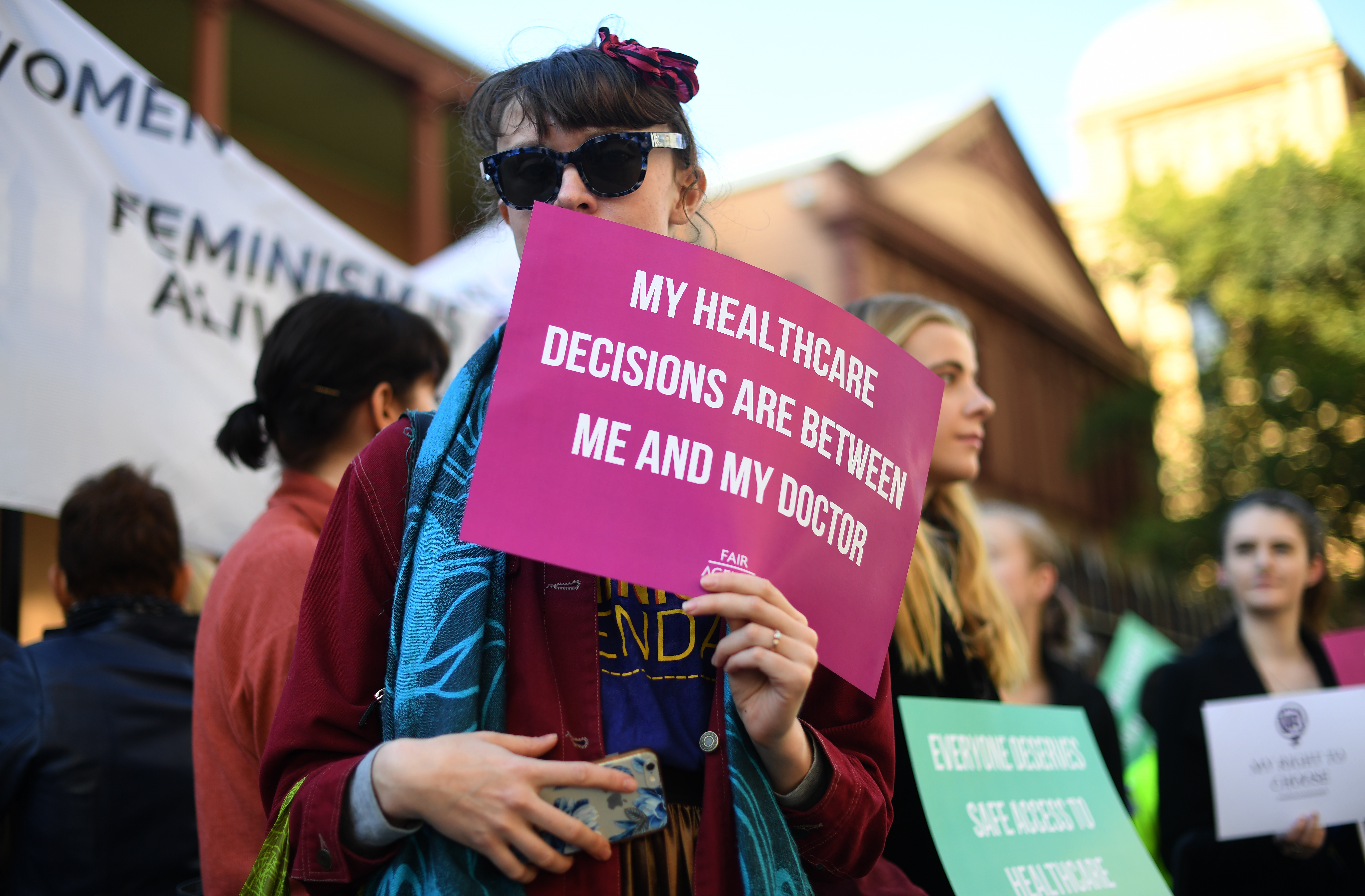 Demonstrators in favour of safe buffer-zones around NSW abortion clinics stand outside the NSW State Parliament building in Sydney, Thursday, May 24, 2018. 