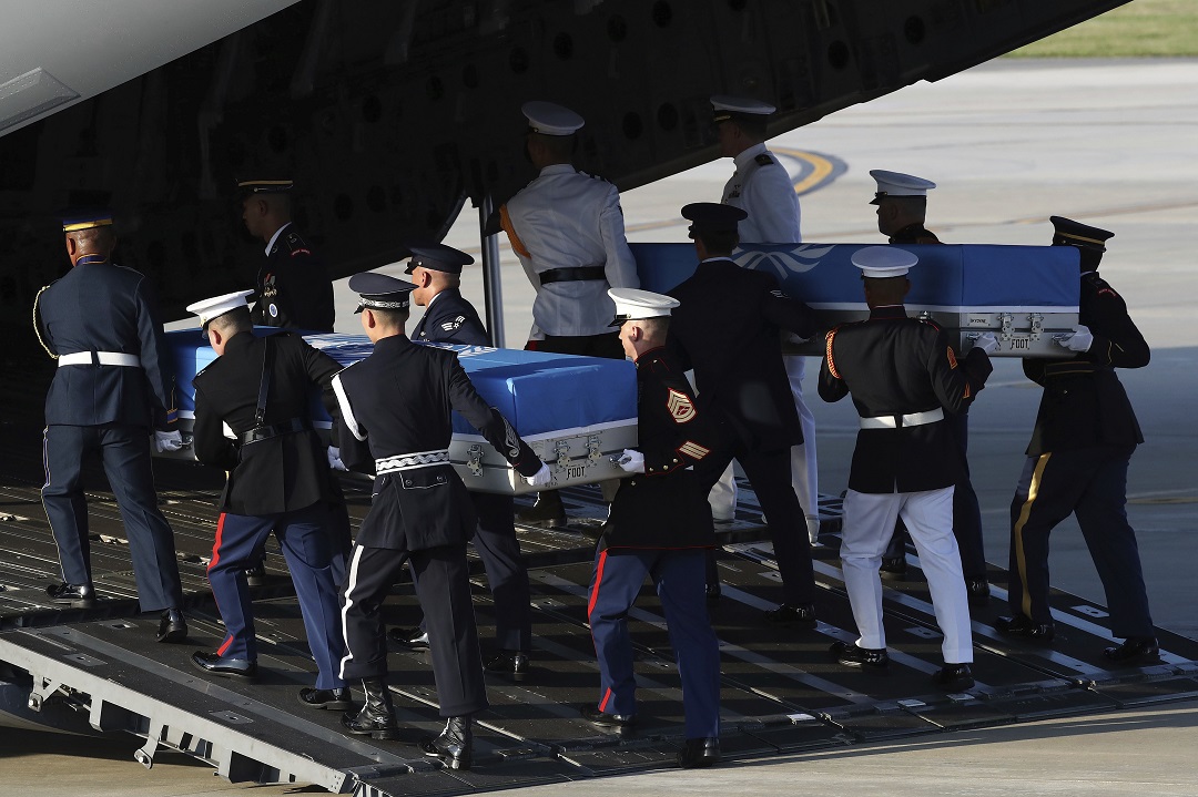 UN honor guards carry a coffin containing the remains of a US soldier who was killed in the Korean War.