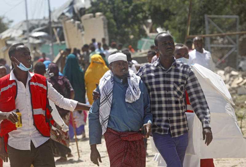 Somali medical personnel help a civilian who was wounded in a blast outside the compound of a district headquarters in the capital Mogadishu, Somalia 