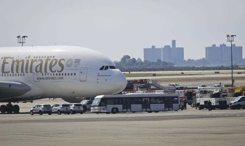 Emergency response crews gather outside a plane at New York's Kennedy Airport amid reports of ill passengers aboard a flight from Dubai, Wednesday Sept. 5, 2018.