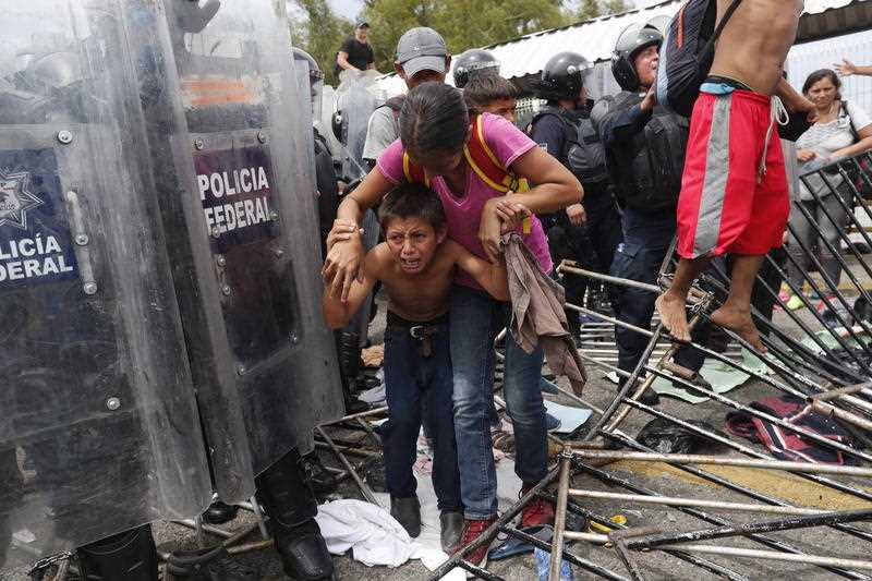 Central American migrants break through a police barricade, on the Mexico-Guatemala border. 