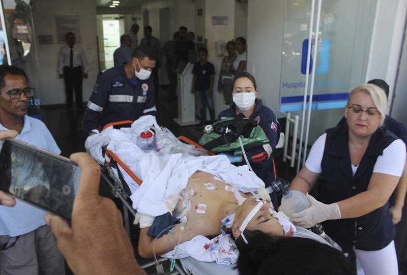 A teenager who was injured during the shooting is carried into hospital.