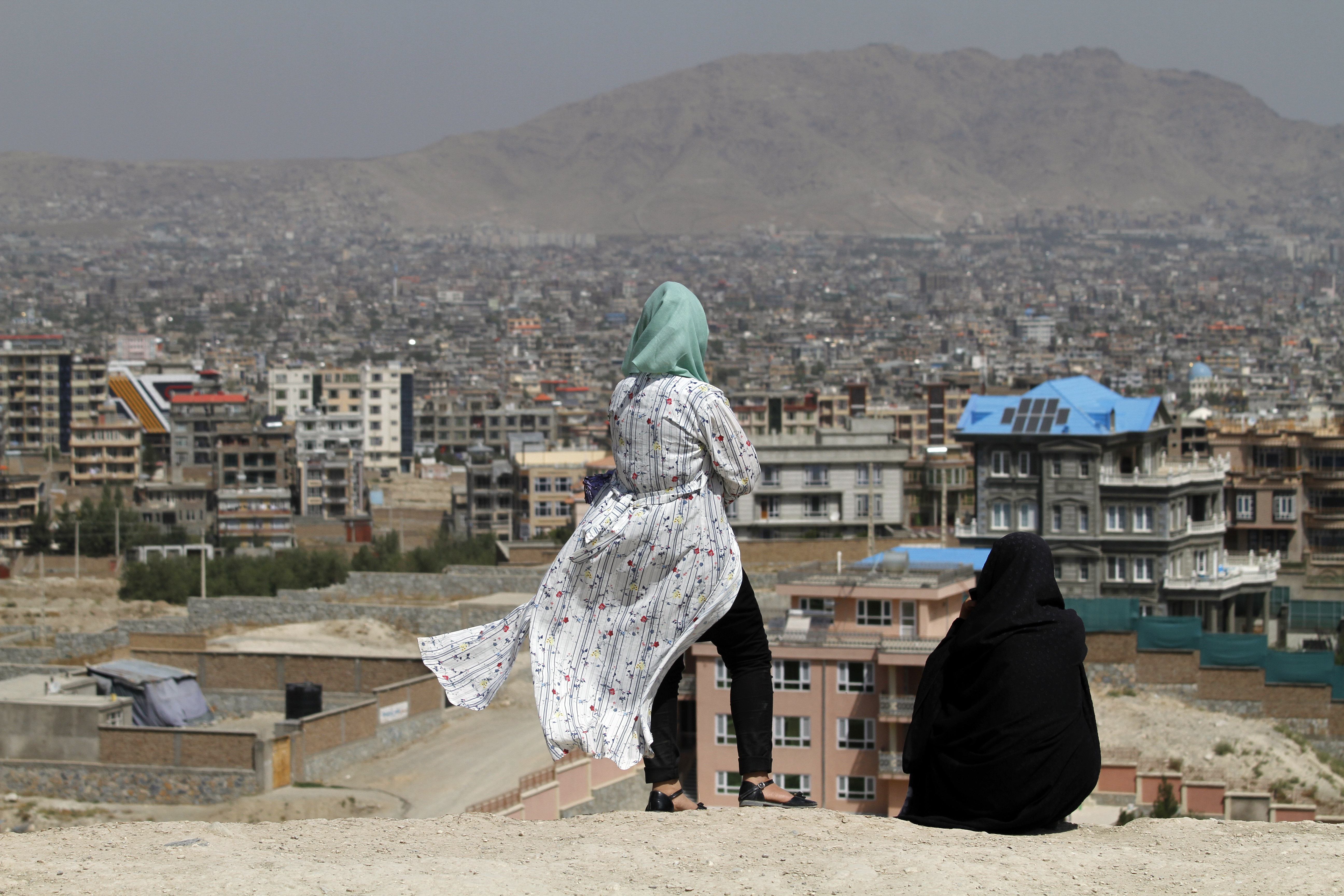 Afghan women look at the skyline of Kabul, Afghanistan, Monday, Sept 14, 2020. (AP Photo/Rahmat Gul)