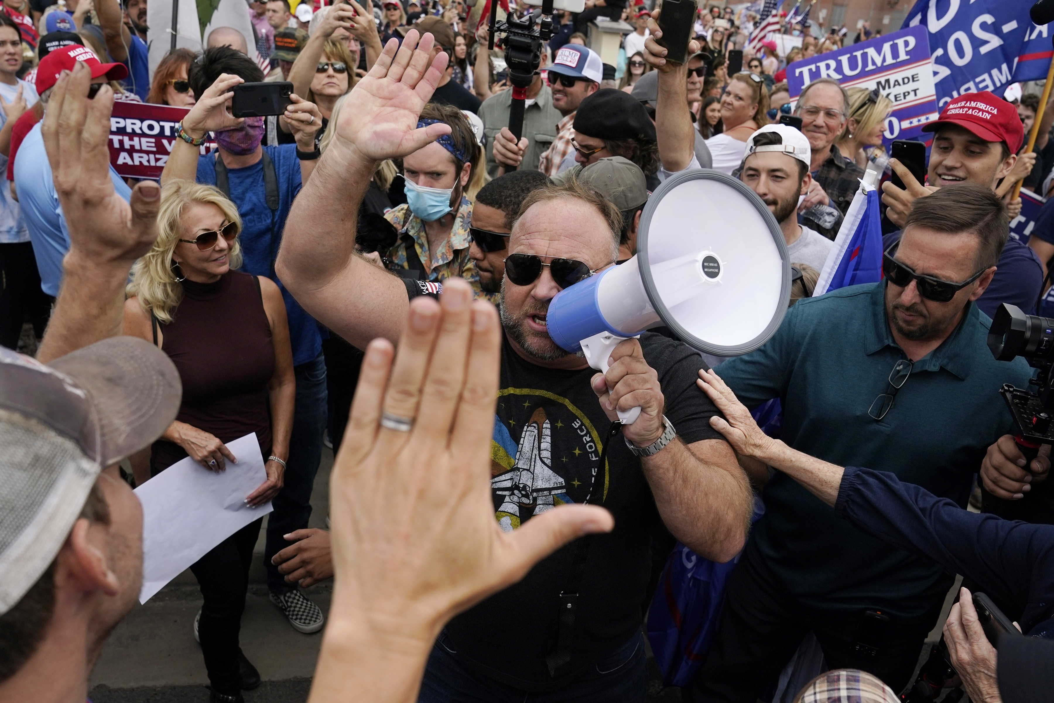 Far-right radio talk show host Alex Jones, center, greets supporters at a rally for President Donald Trump outside the Maricopa County Recorder's Office Friday, Nov. 6, 2020, in Phoenix. (AP Photo/Ross D. Franklin)