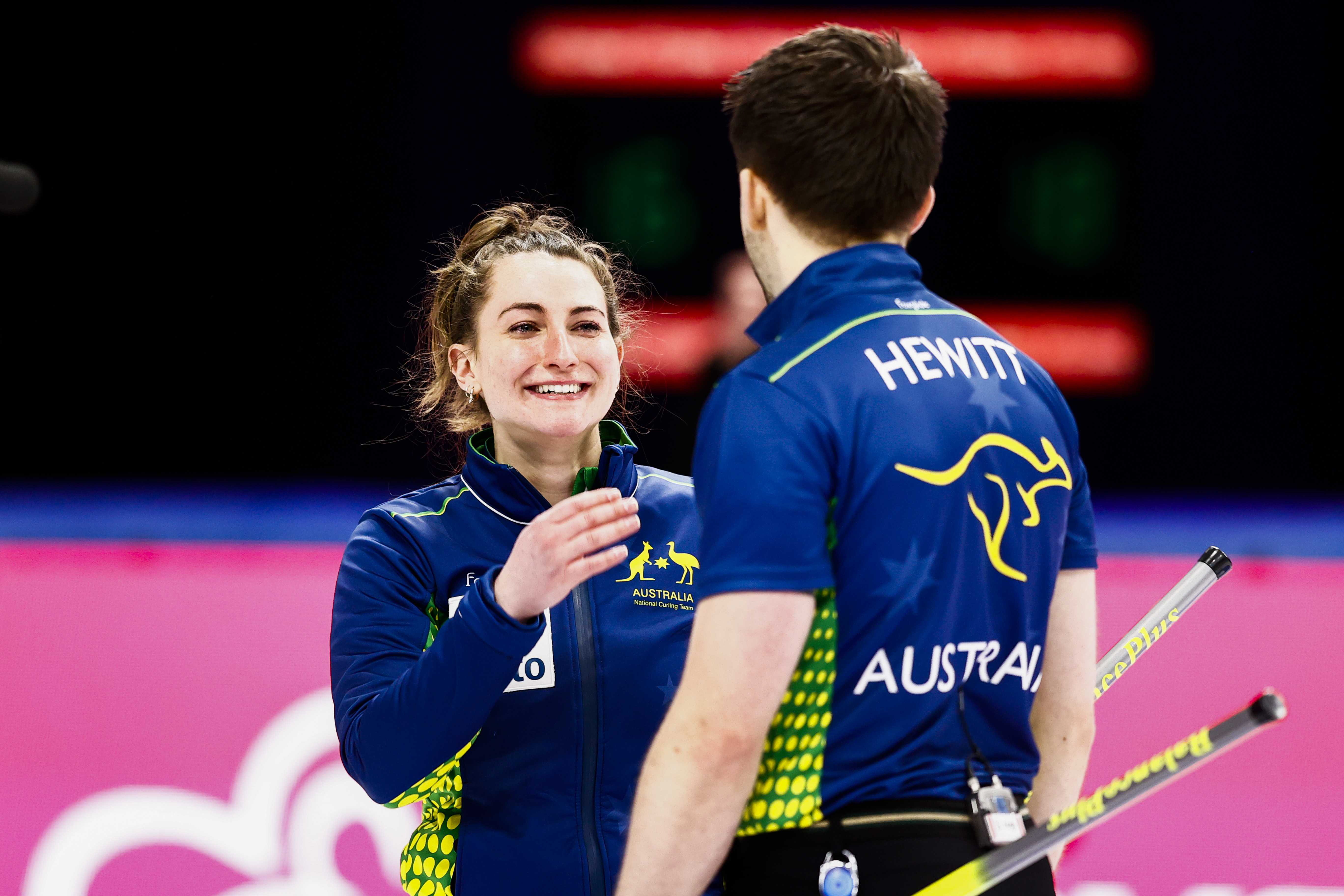 Tahli Gill and Dean Hewitt (R) of Australia react after winning the mixed doubles play-off match at the Beijing 2022 Olympic Qualification curling tournament 