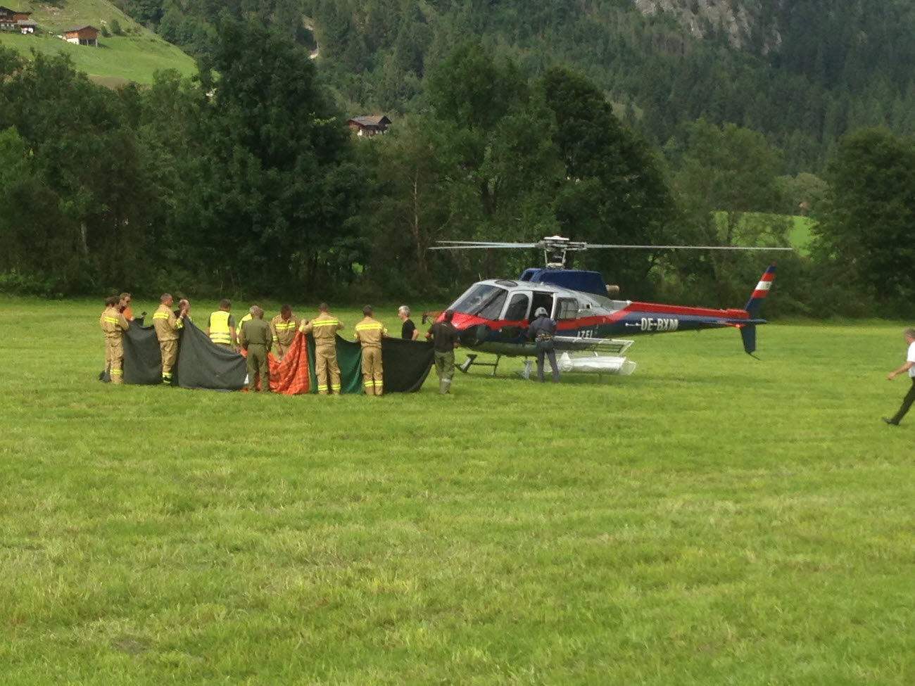 Rescue workers stand next to a police helicopter in Krimml in the Austrian province of Salzburg, Sunday, Aug. 27, 2017. 