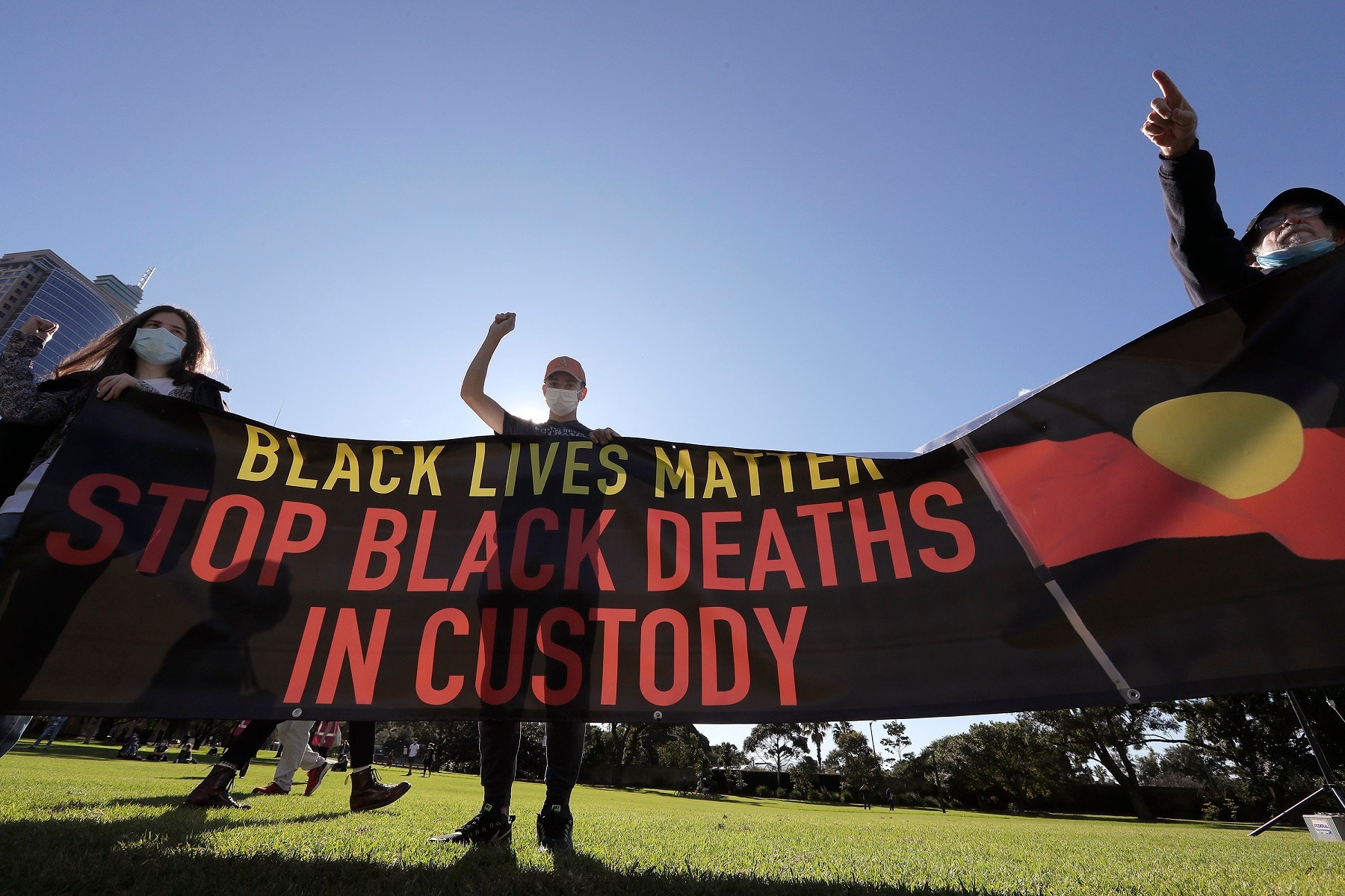People hold a banner as thousands gather at a rally supporting the Black Lives Matter and Black Deaths in Custody movements in Sydney, Sunday, July 5, 2020. (AP Photo/Rick Rycroft)