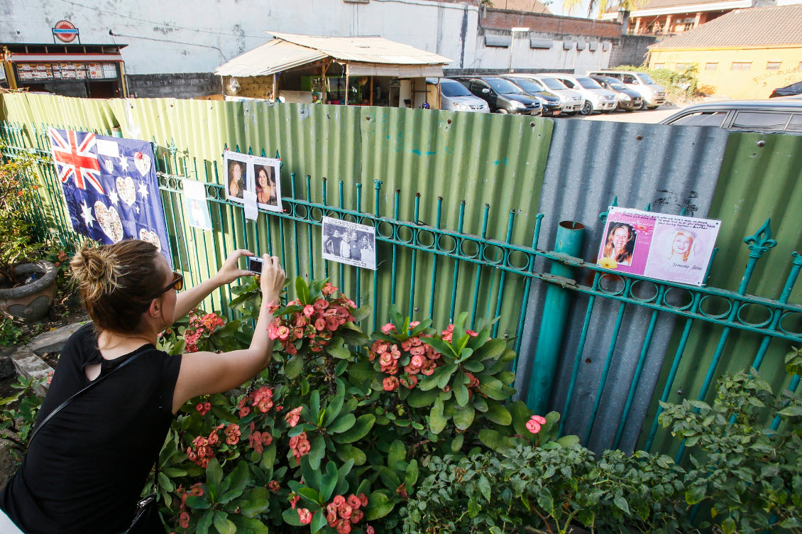A tourist takes a picture at the former site of the Sari Club which is one of the 2002 Bali bomb sites, now used as a car park, in Kuta, Bali, Indonesia, 12 October 2014, the 12th anniversary of the bombings (AAP)