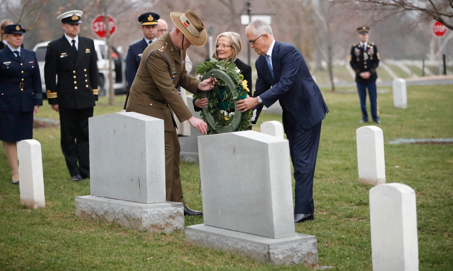 Australian Prime Minister Malcolm Turnbull, right, with his wife Lucy Turnbull, center, lay a wreath at the gravesite of Francis D. Milne