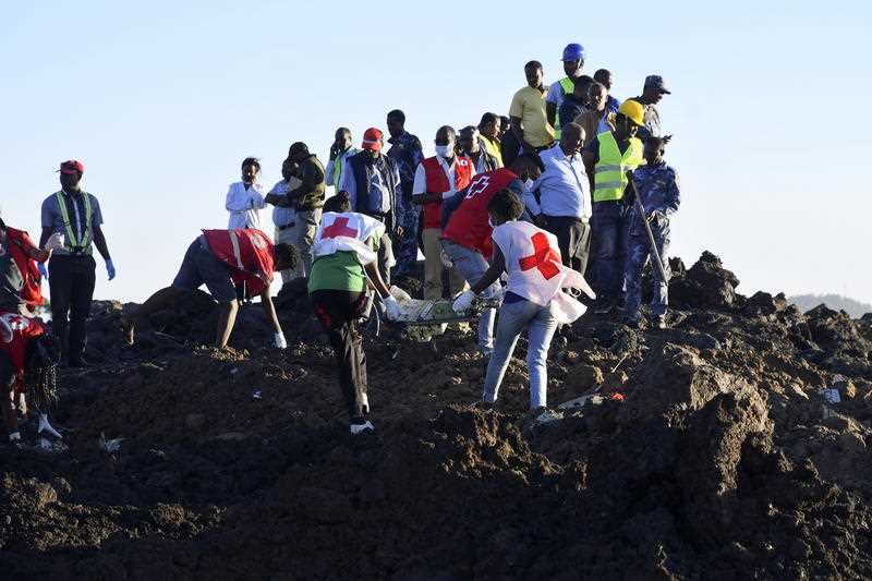 Rescue workers carry wreckage at the crash site of Ethiopia Airlines Boeing 737 Max-8.