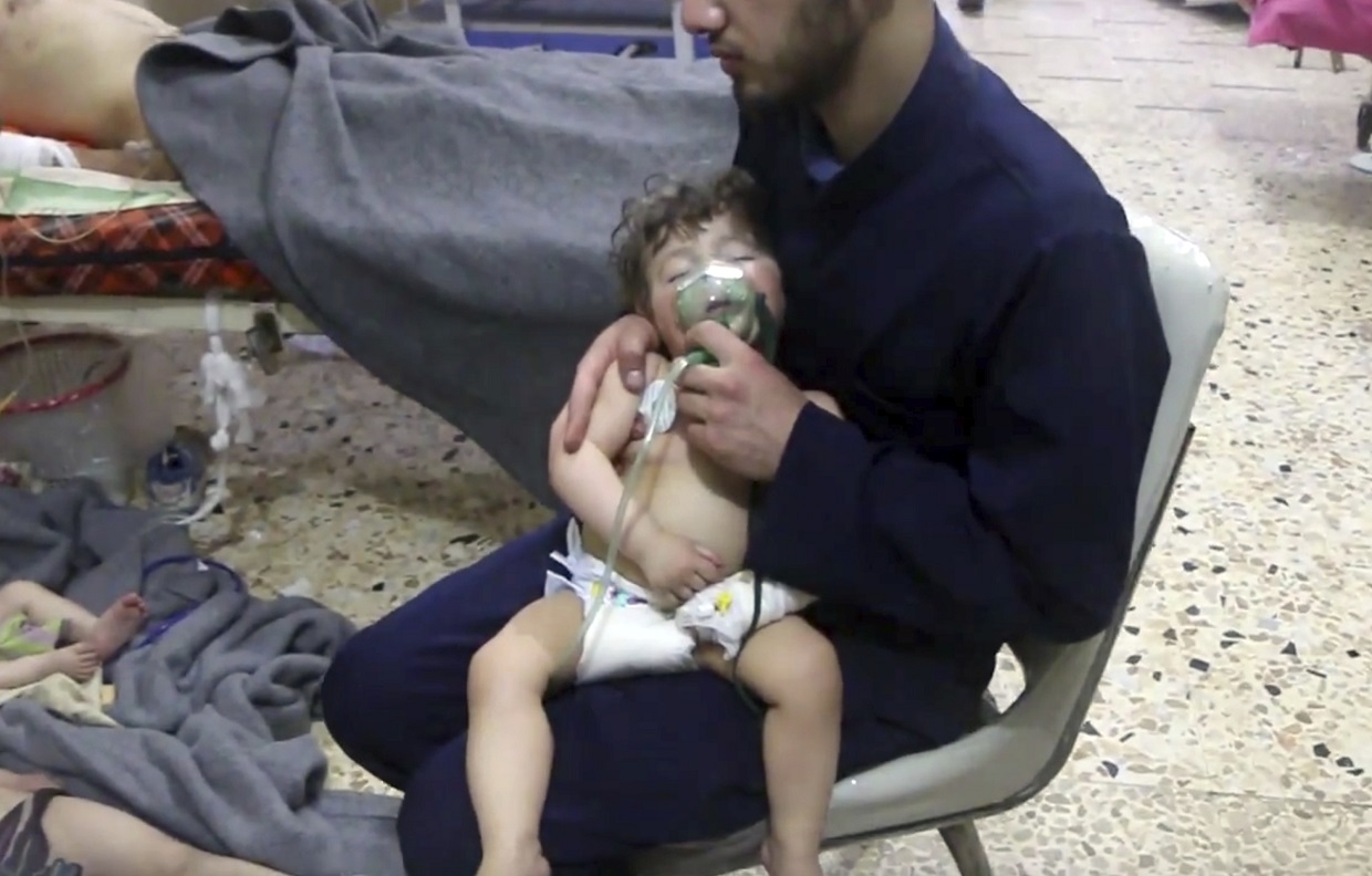 A medical worker giving toddlers oxygen through respirators following an alleged poison gas attack in the opposition-held town of Douma.