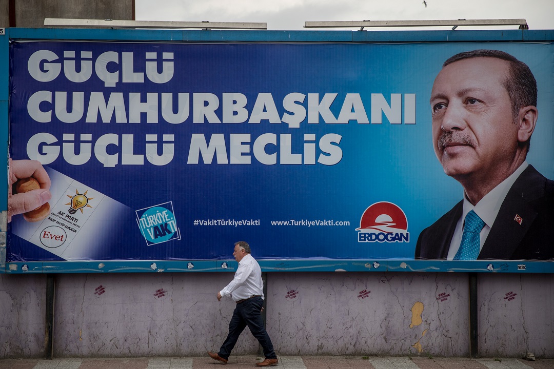 A man walks past a poster of Turkey's President Recep Tayyip Erdogan.