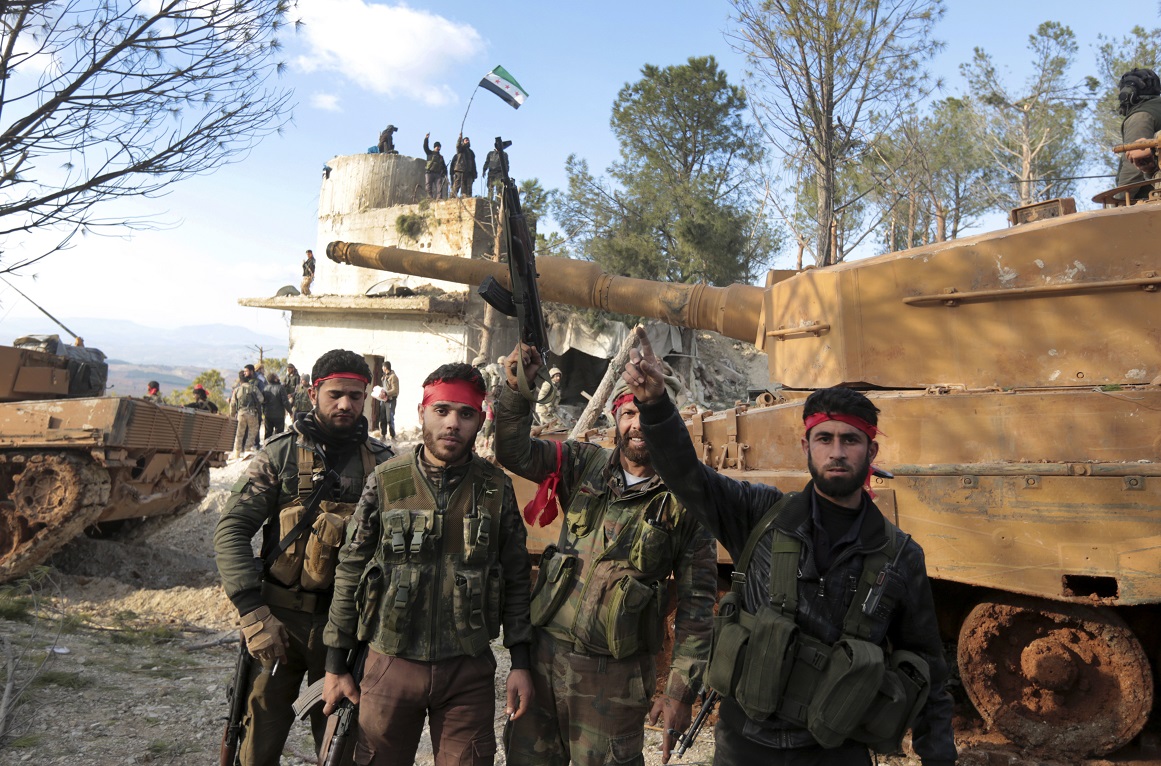 Pro-Turkey Syrian fighters, centre, and Turkish troops secure the Bursayah hill, which separates the Kurdish-held enclave of Afrin.