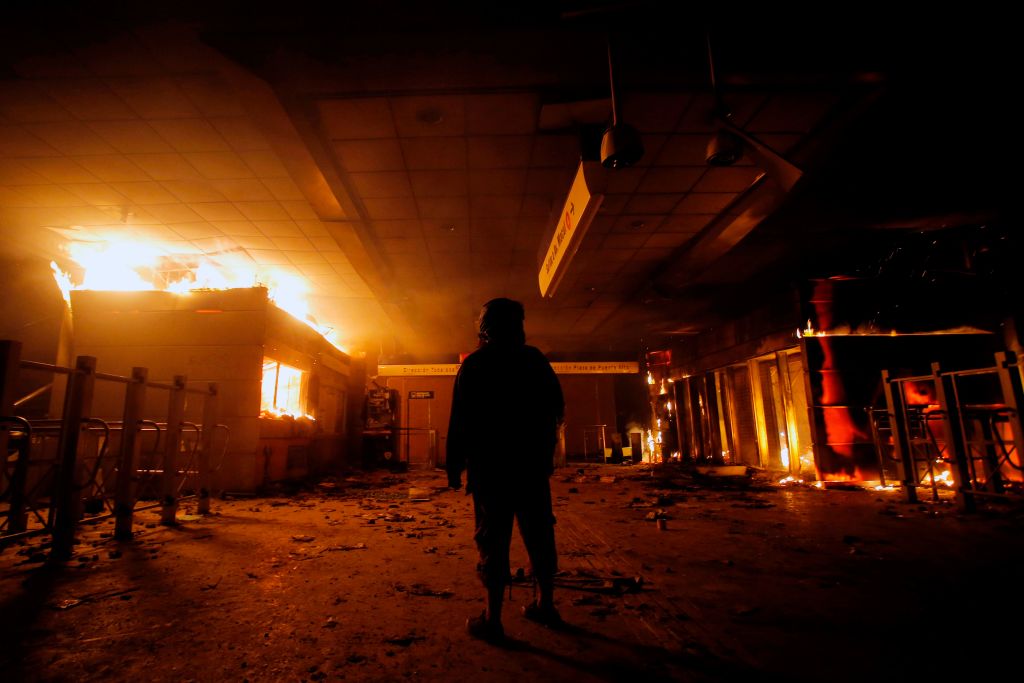View of Macul Metro station set on fire by protesters during a mass fare-dodging protest in Santiago, on October 19, 2019.