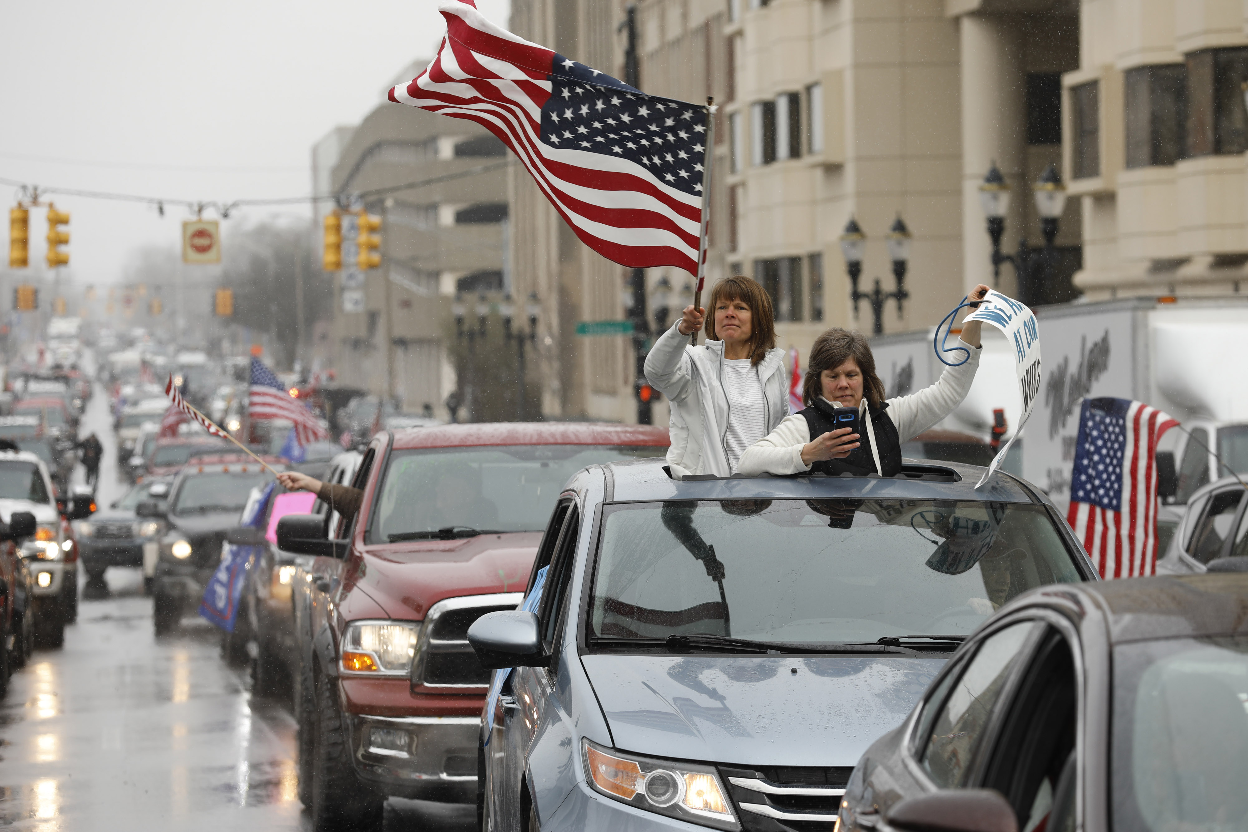 People in their vehicles protest against excessive quarantine orders from Michigan Governor Gretchen Whitmer