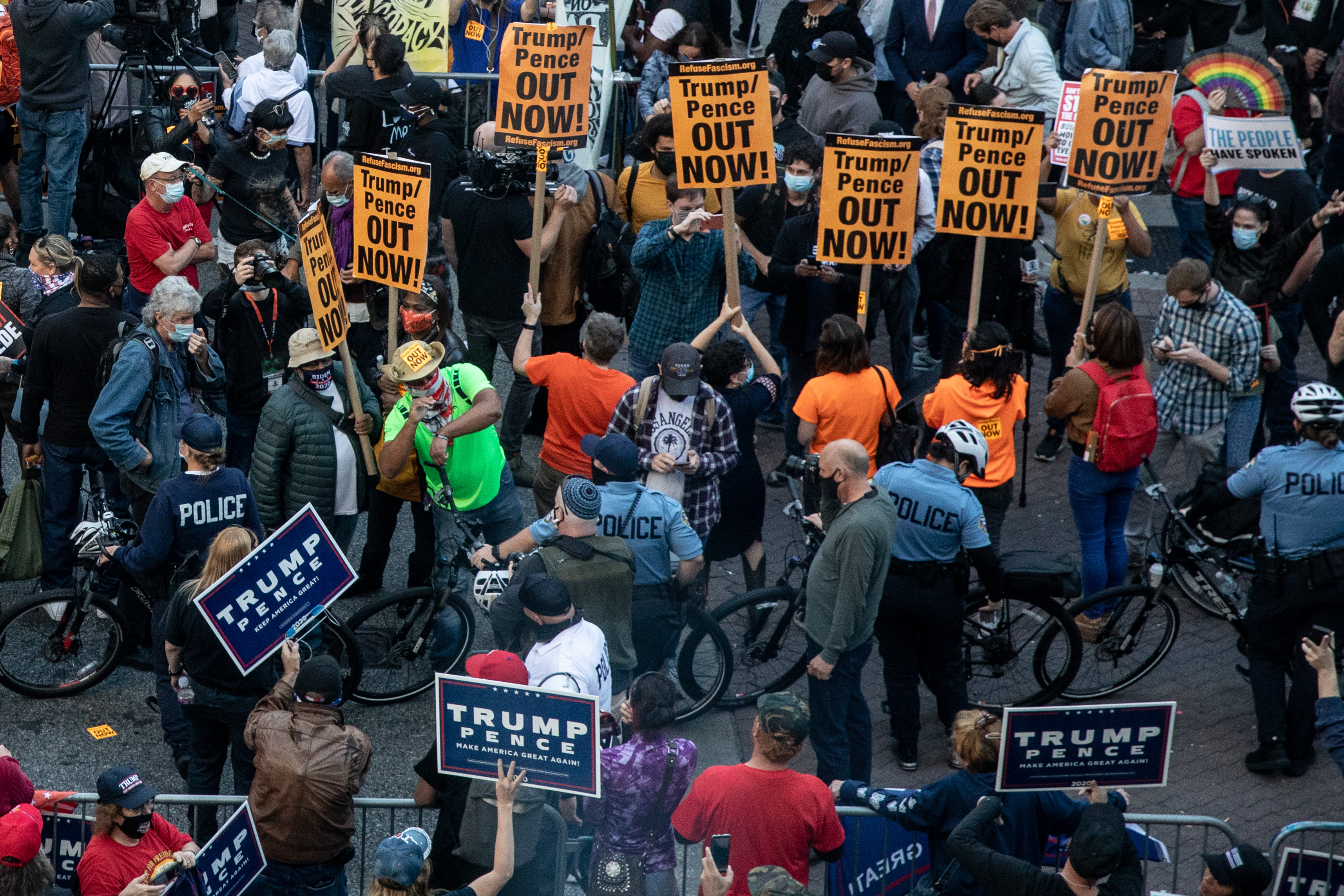 Police officers stand between protesters supporting President Trump (bottom) and people participating in a protest in support of counting all votes.