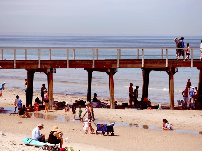Beachgoers at Henley Beach in Adelaide seek relief from the heatwave.
