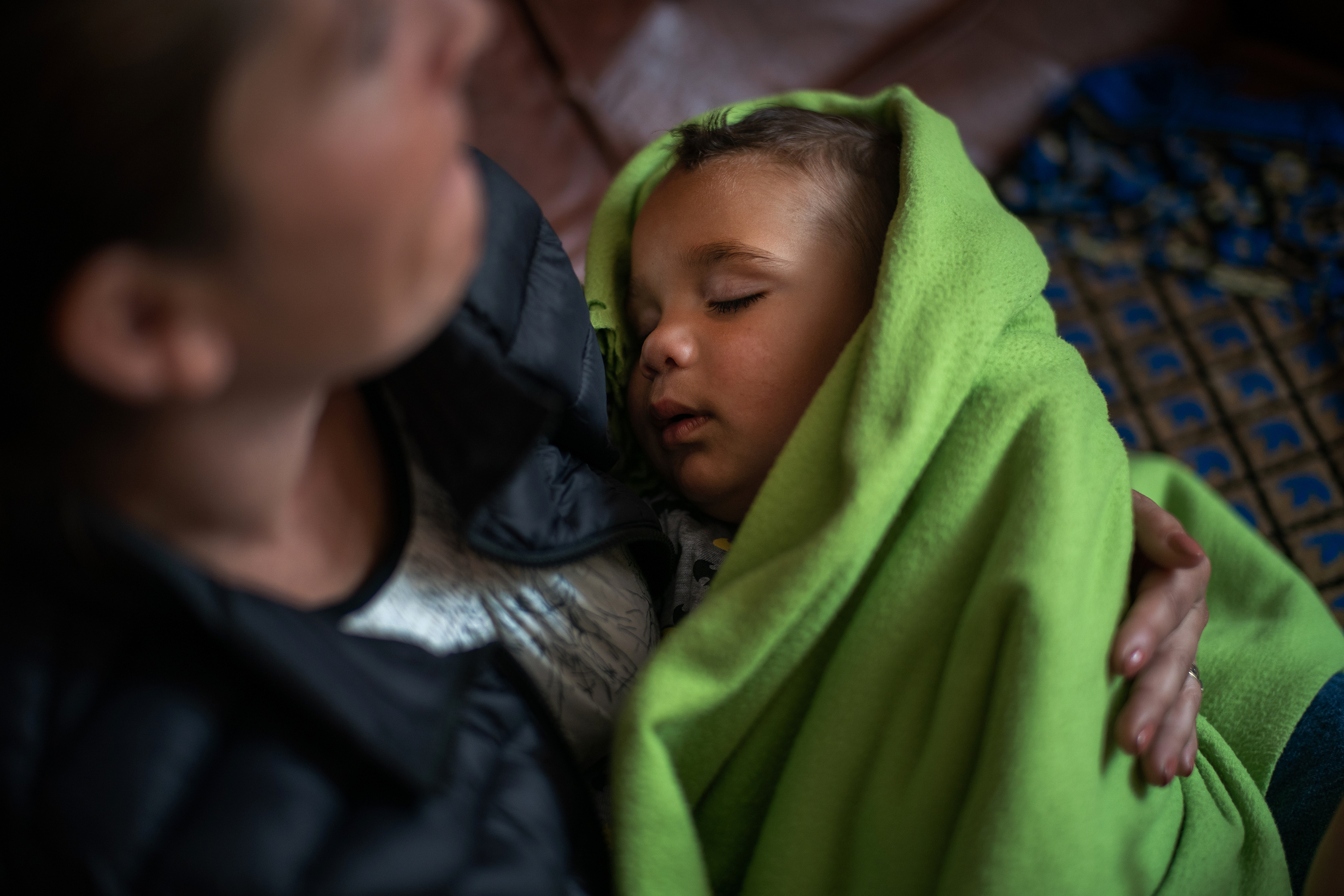 Constantin Mutu, 1, sleeps in his mother's arms in Olteni, Romania.