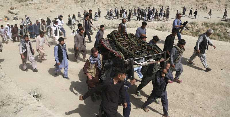 People attend the group burial ceremony of students, a day after the suicide attack which targeted an educational training center in Kabul.