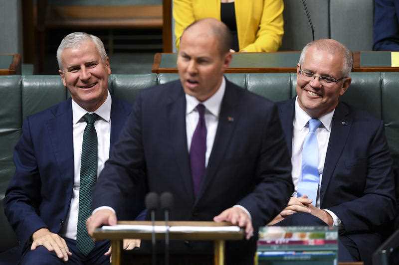 Prime Minister Scott Morrison and Deputy PM Michael McCormack react as Australian Federal Treasurer Josh Frydenberg hands down the budget.