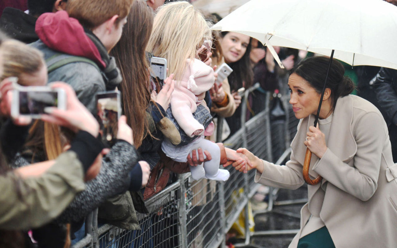 Meghan Markle greets crowds with Prince Harry (not pictured) during a walkabout.