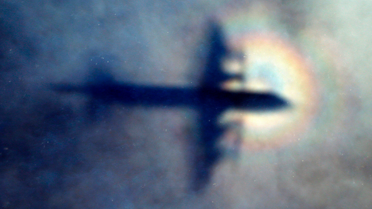 A Royal New Zealand Air Force P3 Orion is seen through low level cloud during the search for MH370 in the southern Indian Ocean.