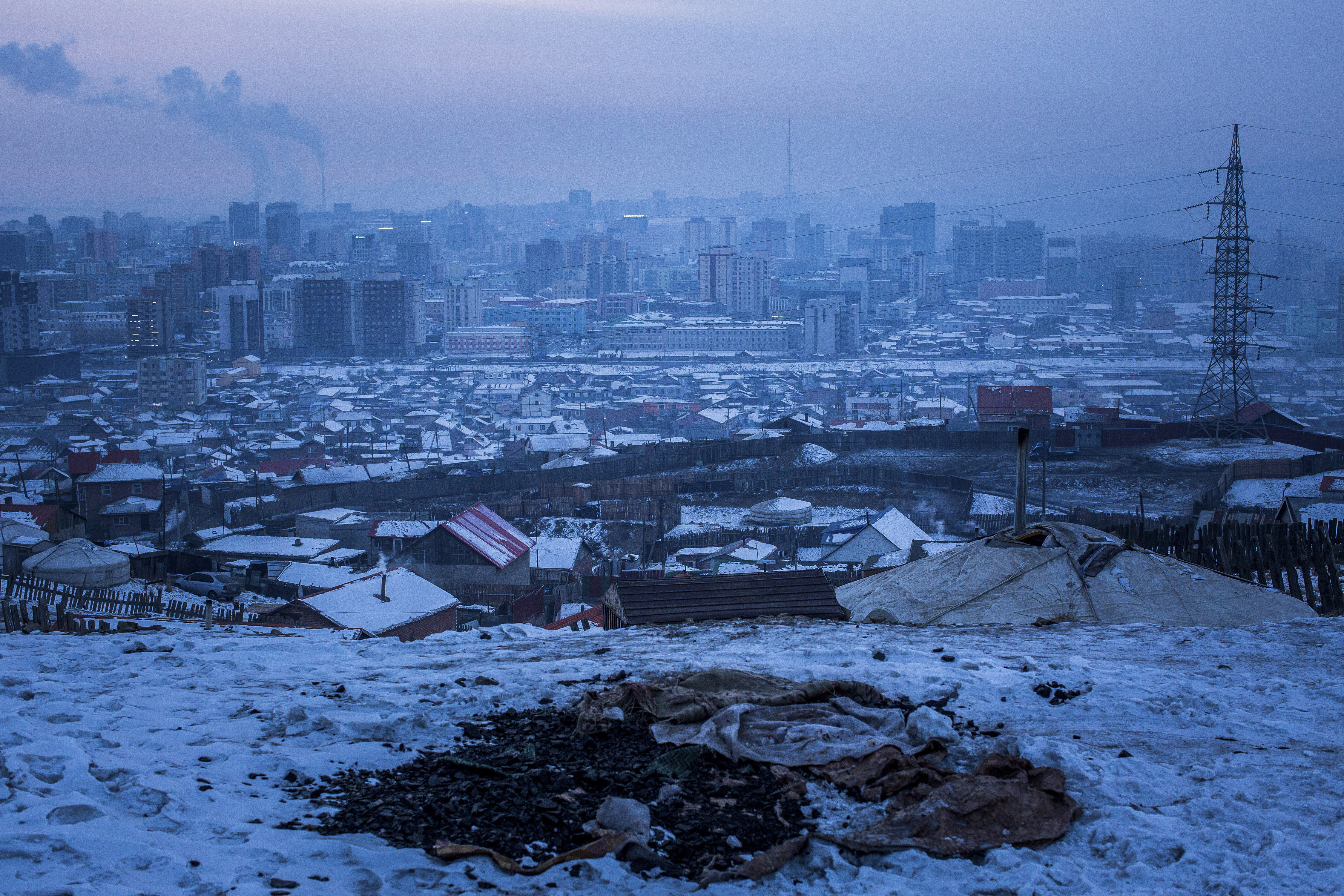 A pile of coal exposed in the snow on an abandoned lot in Ulaanbaatar, Mongolia.