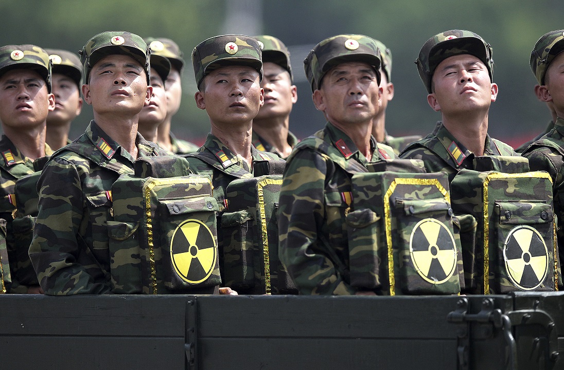 North Korean carry packs marked with the nuclear symbol during a parade.