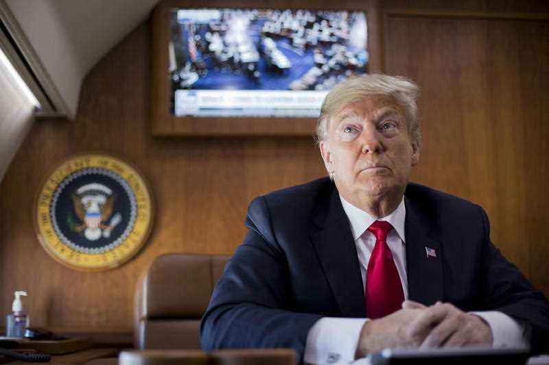 President Donald Trump, on board Air Force One, pauses while watching a live television broadcast of the Senate confirmation vote of his Supreme Court nominee.