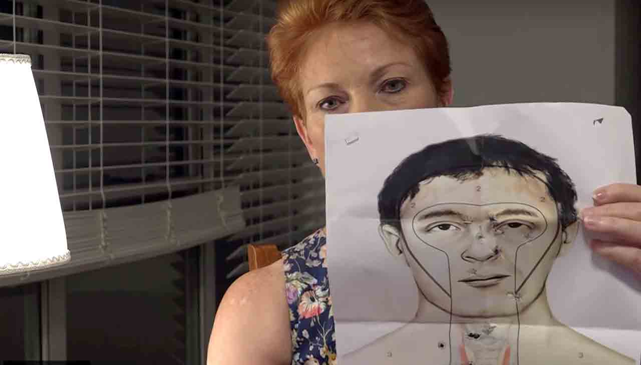 Pauline Hanson holds up her results from target practice with a gun. 