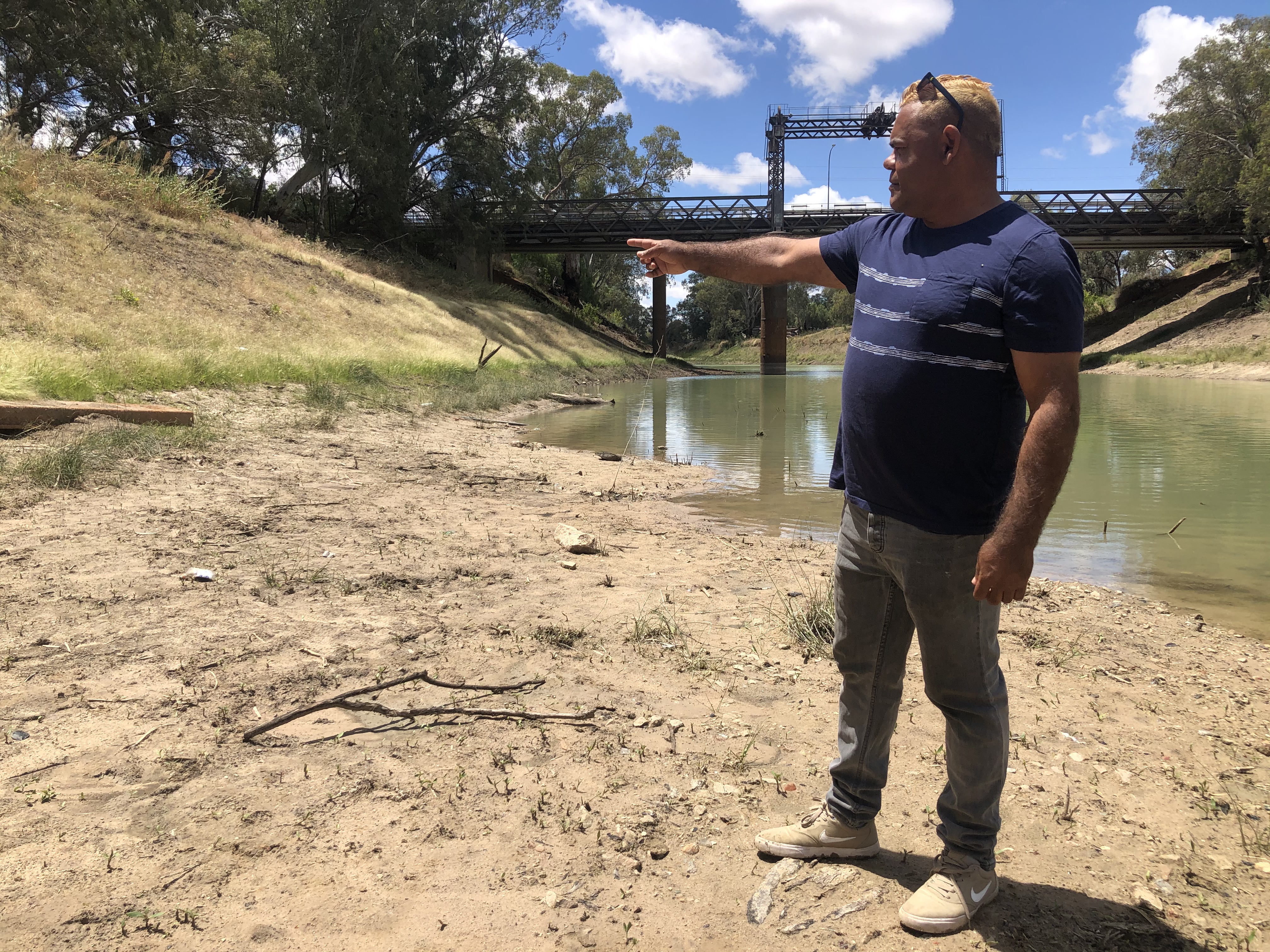 Owen Whyman points to the high water mark on the riverbank. 