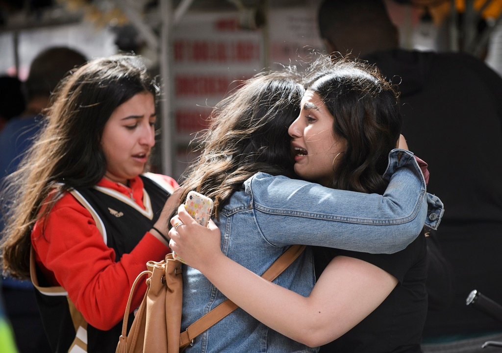 Friends embrace after shots were fired during the Toronto Raptors NBA basketball championship parade in Toronto.