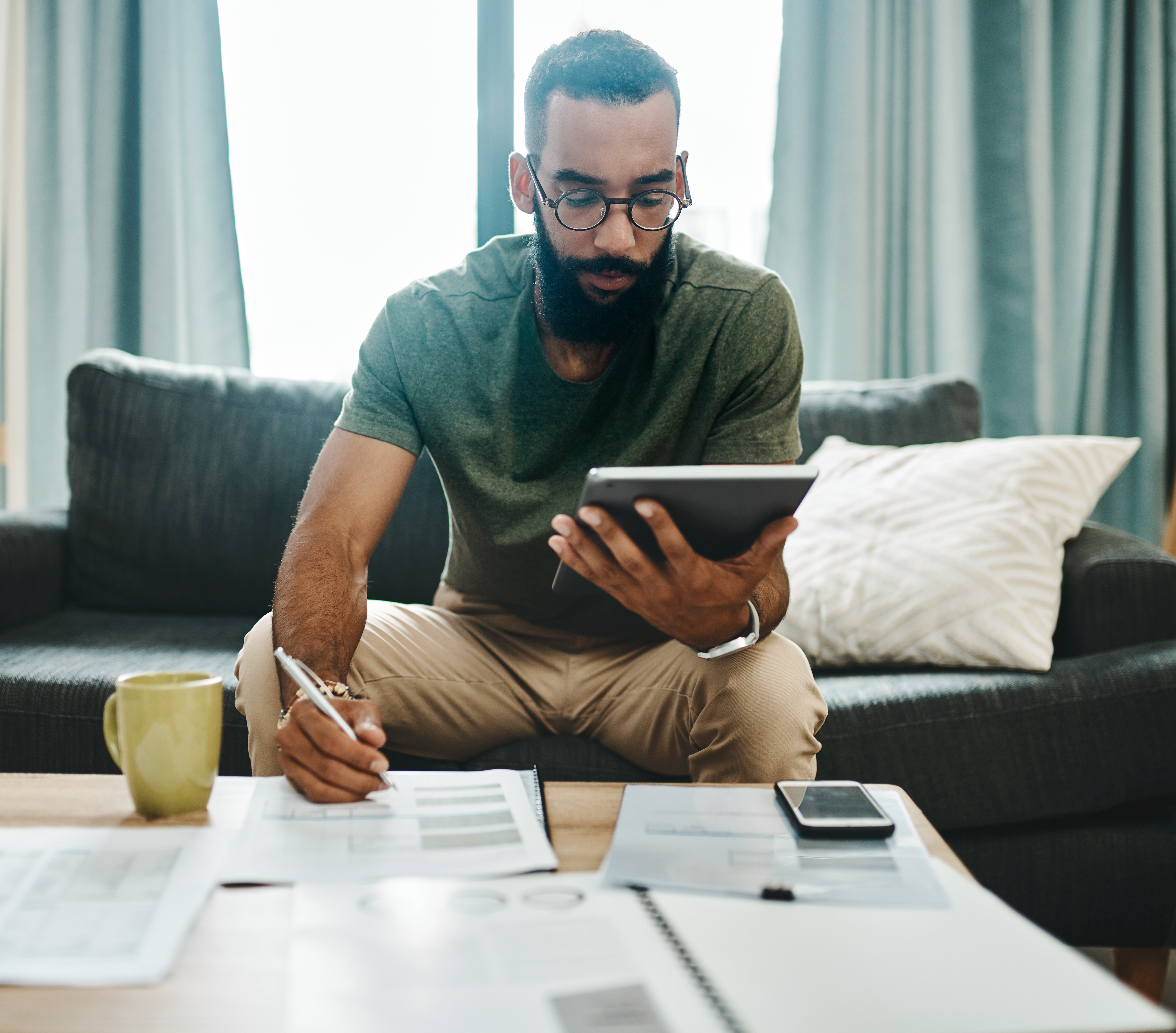 A young man going over his finances ahead of tax time while working from home.