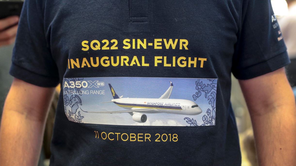 A man wearing a commemorative t-shirt for the flight of Singapore Airlines flight SQ22 at the check-in counter of the Changi Airport in Singapore.