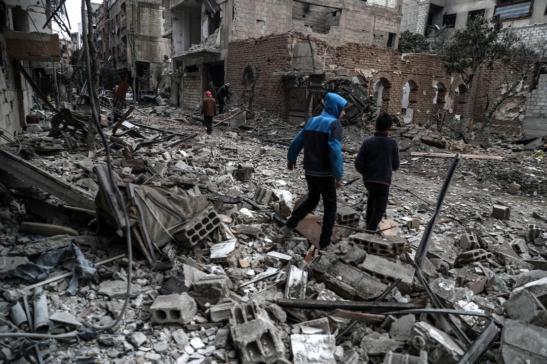 People inspect the rubble of damaged buildings after several airstrikes a day earlier, rebels-held Douma, Eastern Ghouta.