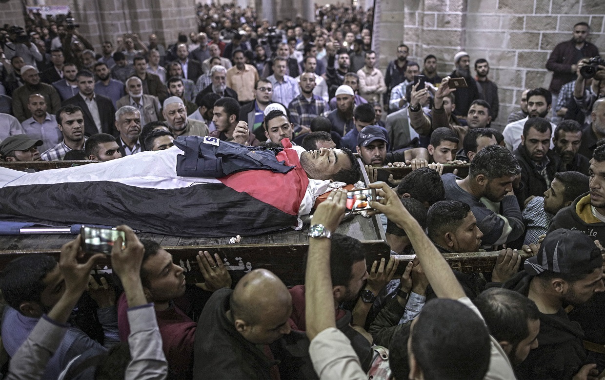 Palestinians mourners carry the body of cameraman Yasser Mourtaja, 30, during his funeral in Gaza City on April 7.