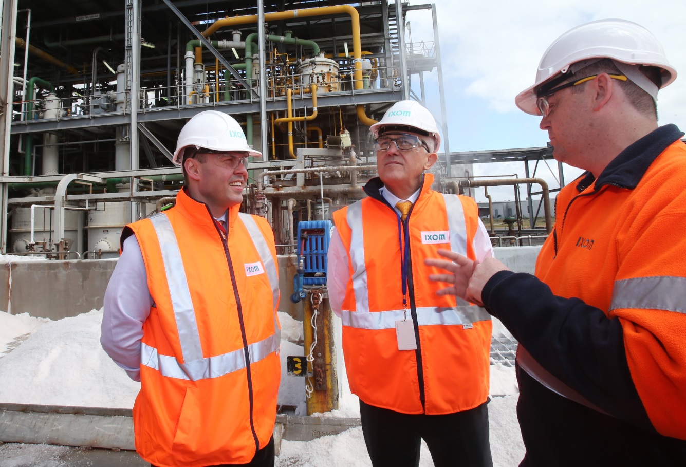 Prime Minister Malcolm Turnbull (centre) and Australian Minister for Energy and the Environment Josh Frydenberg (left) speak to a worker during a tour