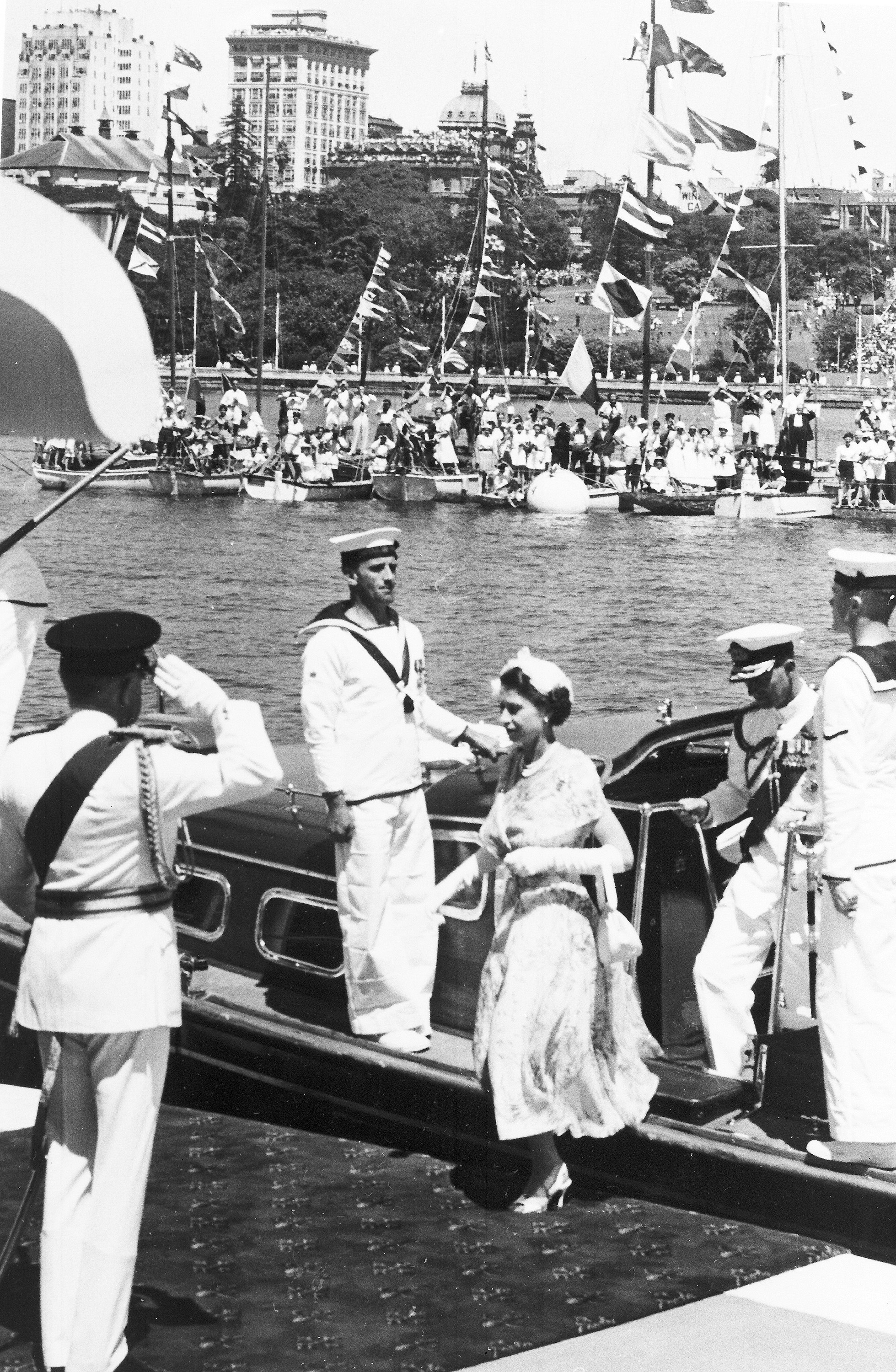 Britain's Queen Elizabeth II, followed by her husband Duke of Edinburgh, steps ashore from the tender at Farm Cove, Sydney, on Feb. 3, 1954. She is greeted, left, by Sir William Slim, Governor-General of Australia. (AP Photo)