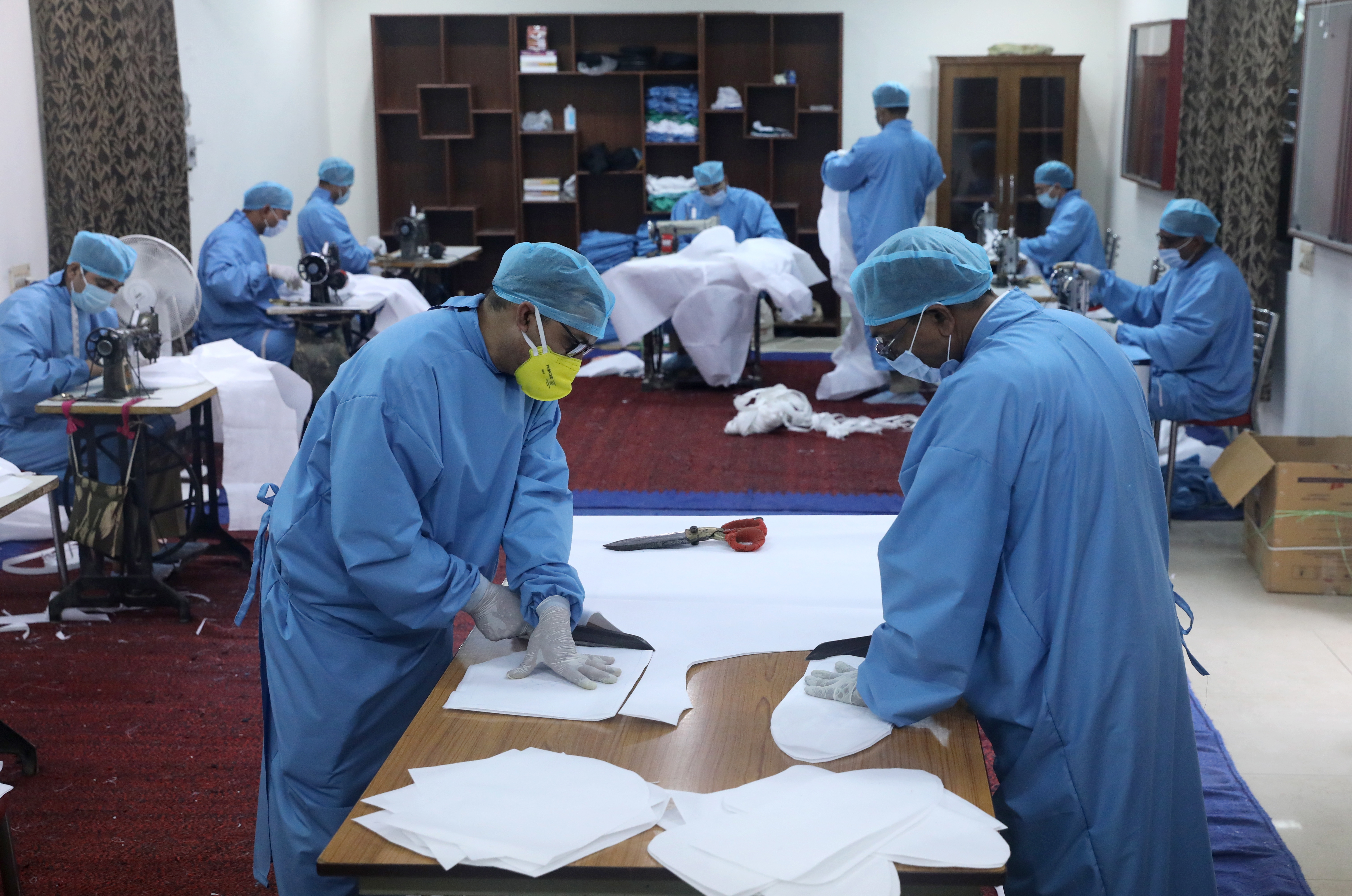 Central Reserve Police Force officials create PPE kits and face masks for health care staff at a CRPF facility in New Delhi, India, 10 April 2020.